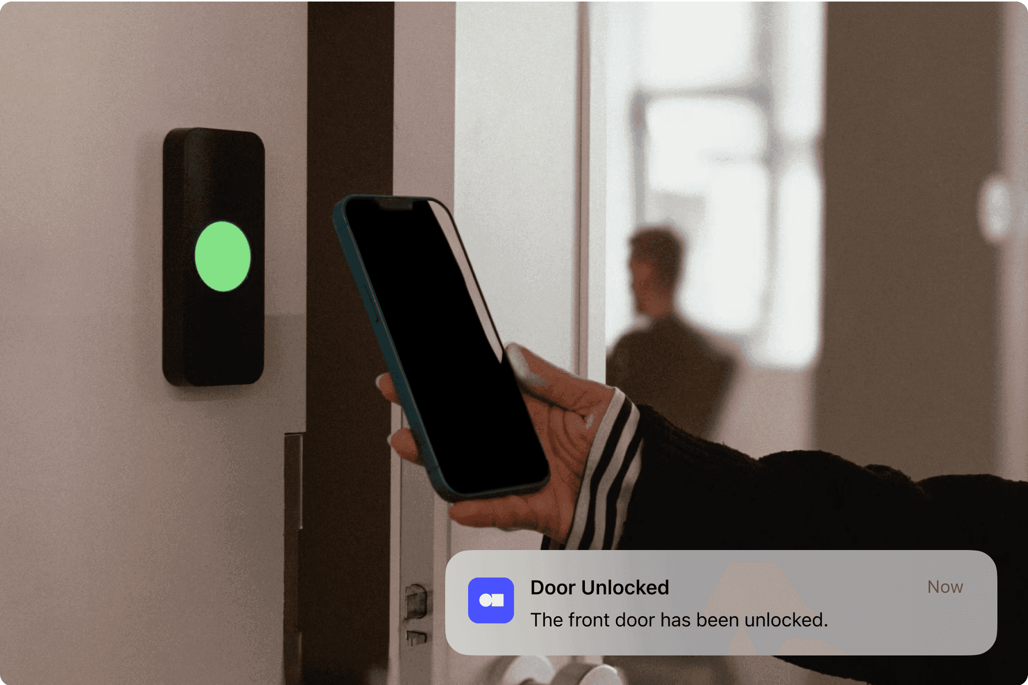 A person using a smartphone to unlock a door, with a notification indicating the door has been unlocked.