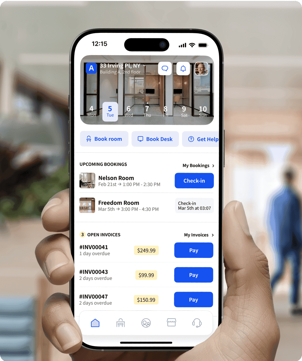 A person holding a smartphone displaying Archie, a workspace booking app. The app shows upcoming bookings for rooms and open invoices that need payment.