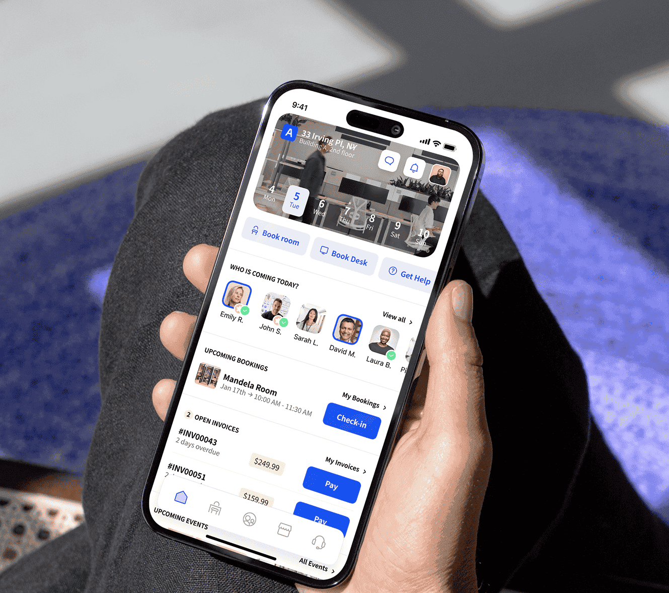 Person holding a smartphone displaying a workspace booking app with upcoming bookings and visitor information.