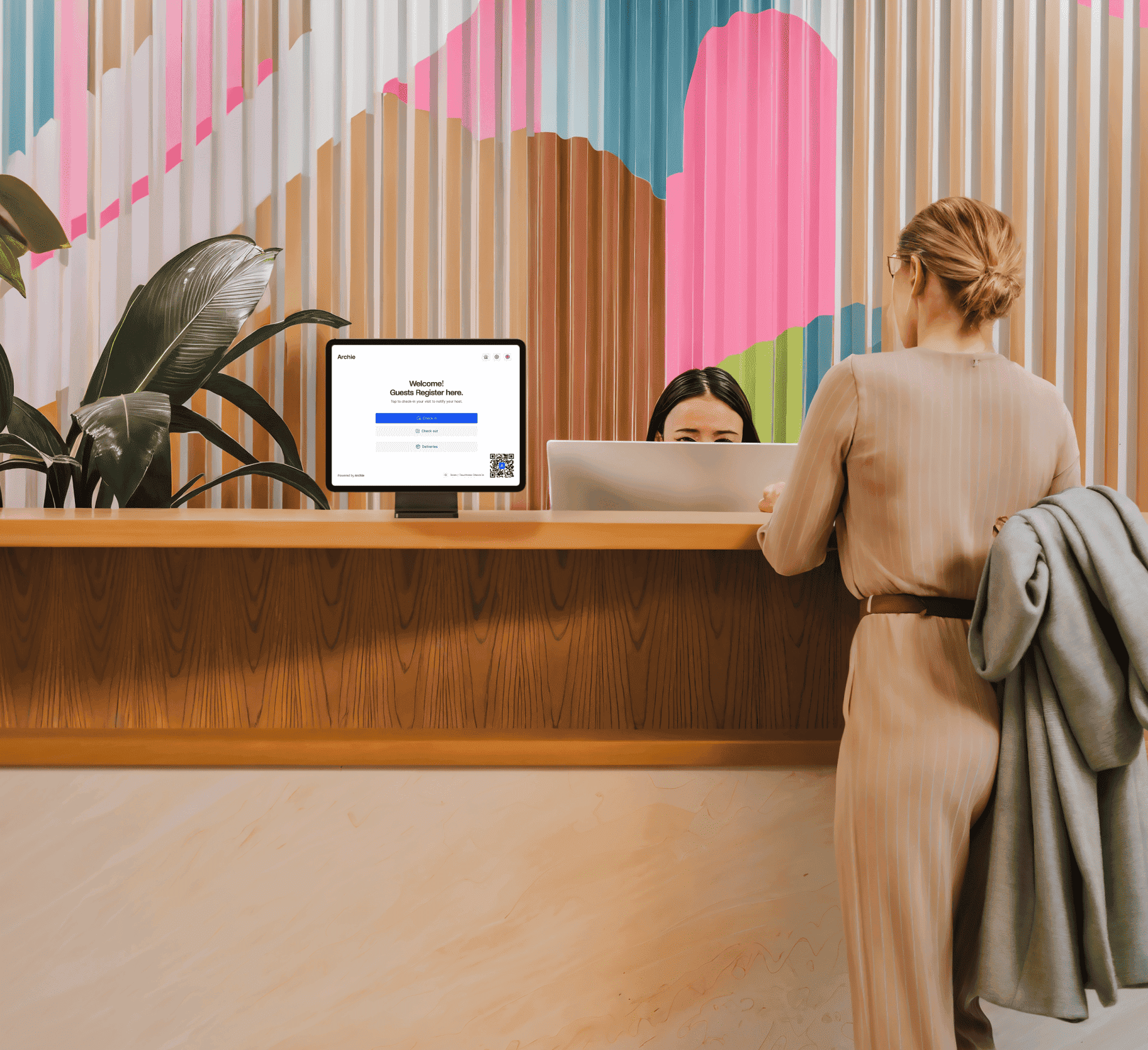 Tablet on a stand at a reception desk with a guest registration screen from Archie Visitors app.