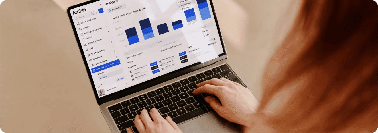 A person using a laptop to view an analytics dashboard in a workspace management application.